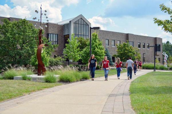 Students walking in front of a brick building on the IU East campus.