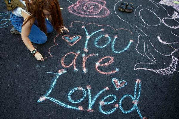 You are loved written on the ground in chalk.