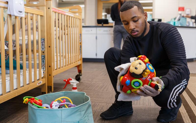 IU student cleans childrens' toys.